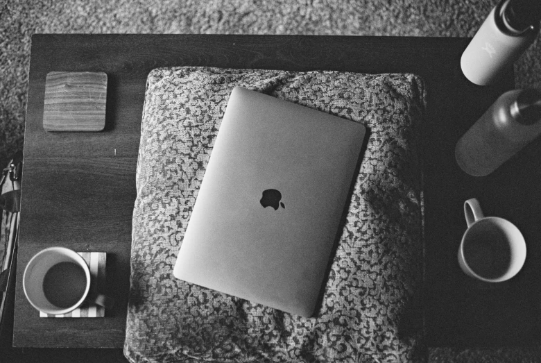 a table with a book, a coffee cup and a smart phone