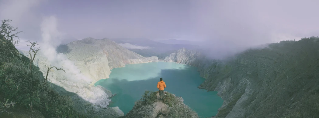 a person is standing on the edge of a high cliff