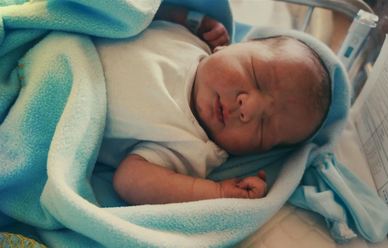 a newborn baby laying in its cage in a hospital