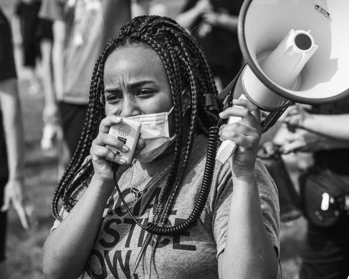 woman holding an megaphone and a napkin in her mouth