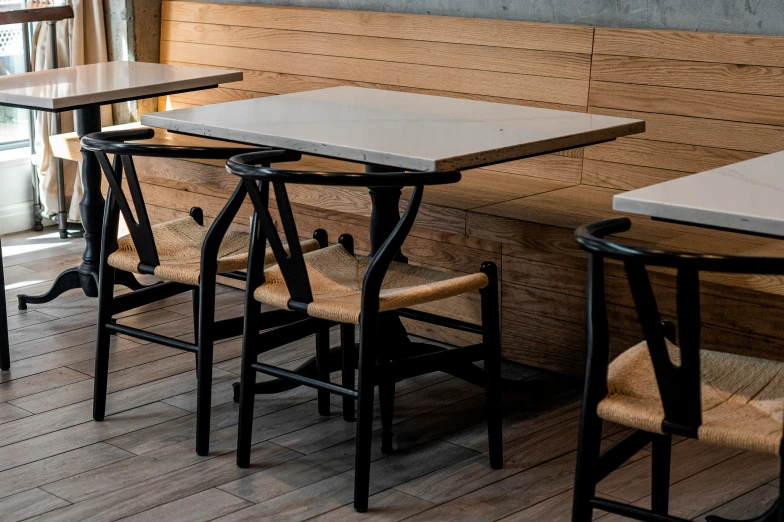 a room with four black barstools in front of a brown wall