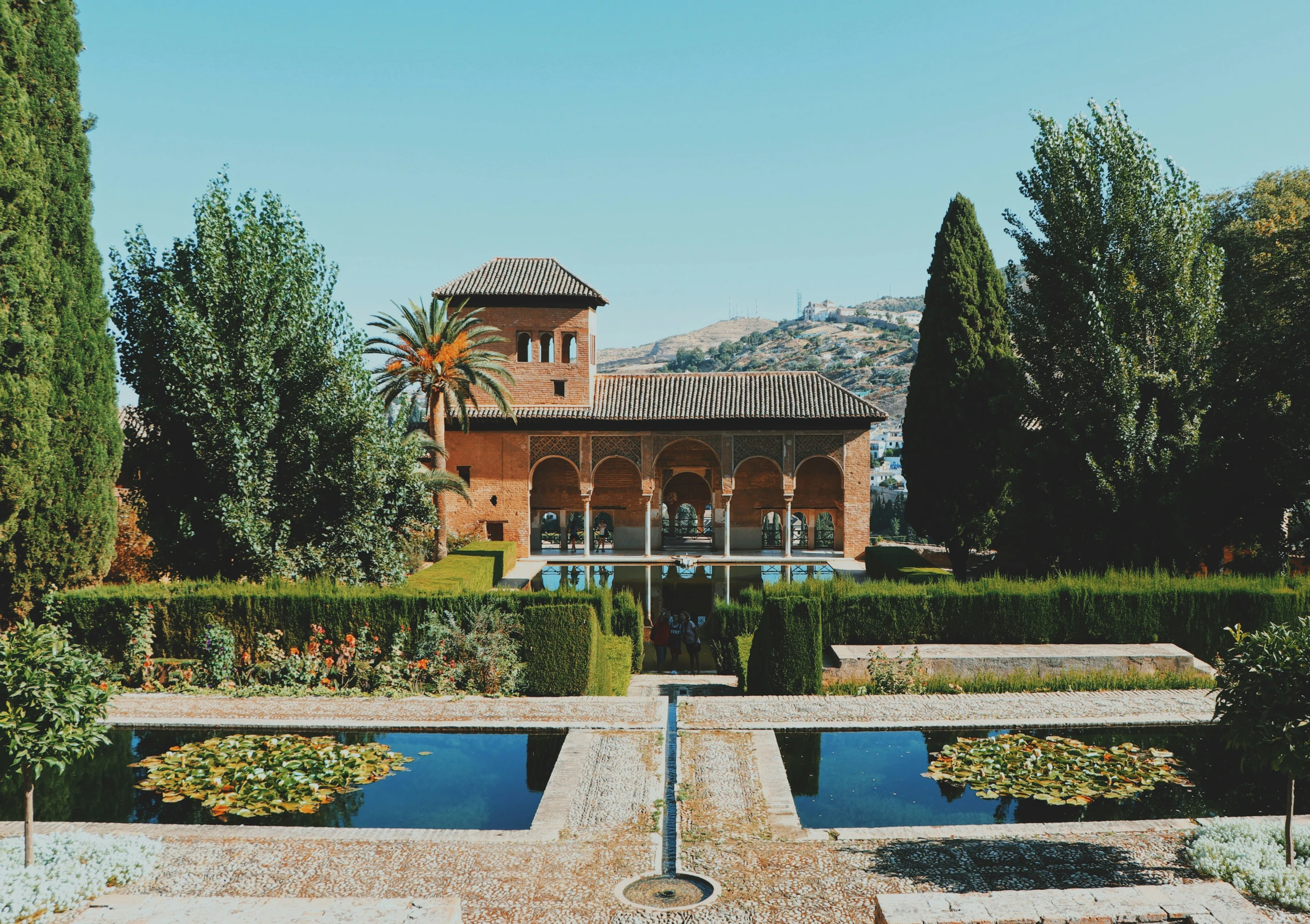 a large pond sits in front of a red brick building