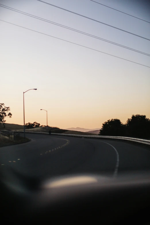 sunset over a street intersection with cars on it