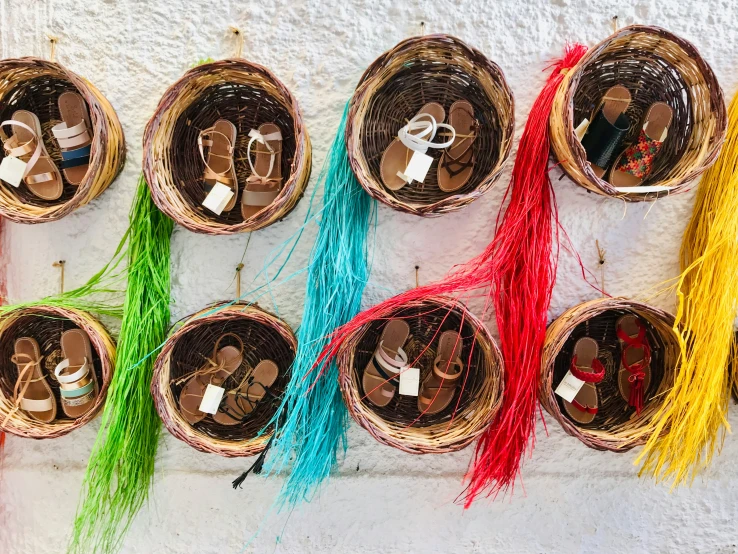 many decorations with tassels hang on a white wall