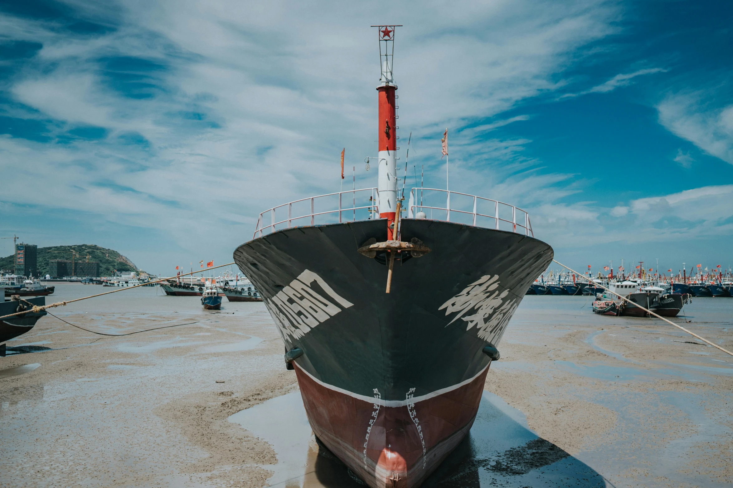 a big ship sitting on the beach next to other ships