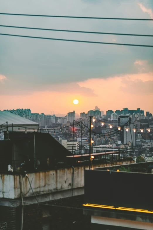 the sun setting over city with power lines