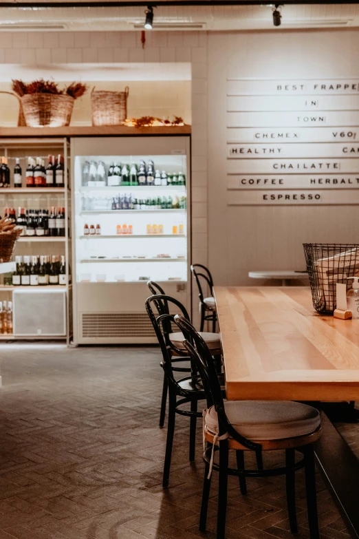 the interior of a grocery store with wooden table and chairs