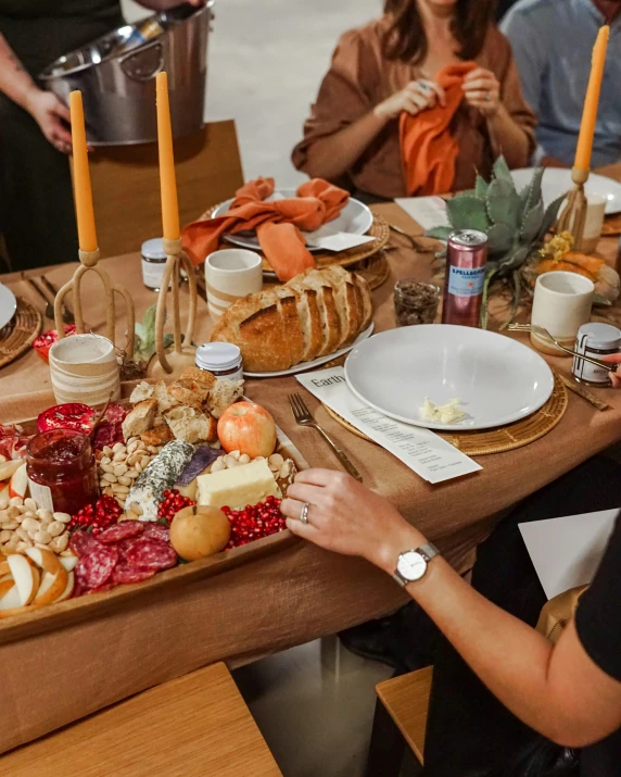 a woman is setting the table full of food