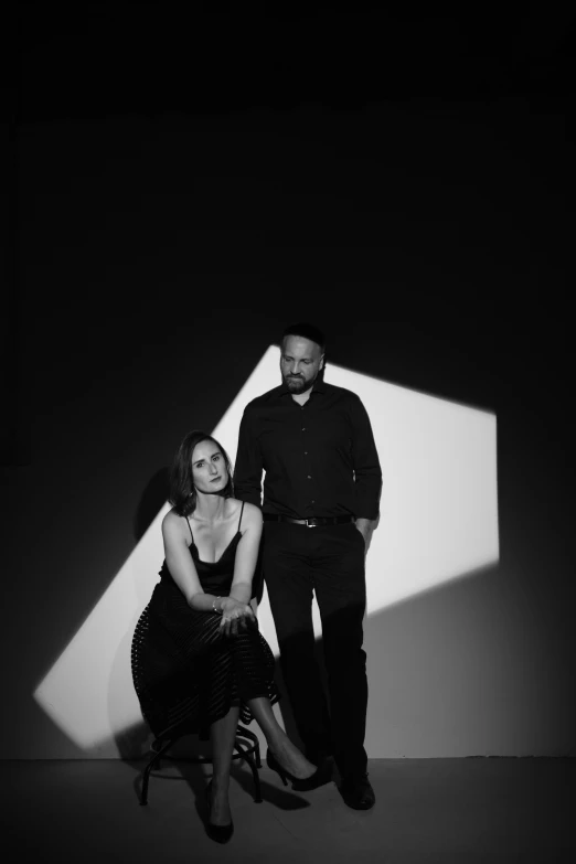 two people are posing for a black and white po