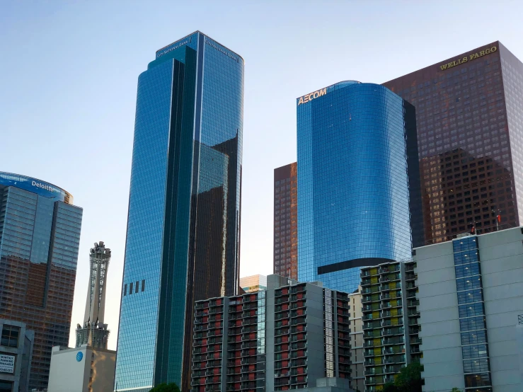 a couple of tall buildings sitting under a blue sky