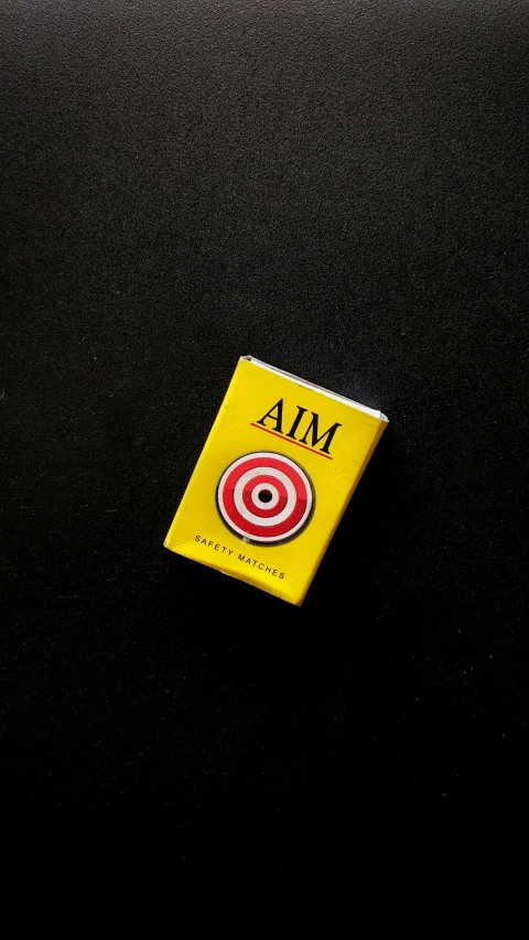 a yellow piece of matchbook with red and black circle in the center