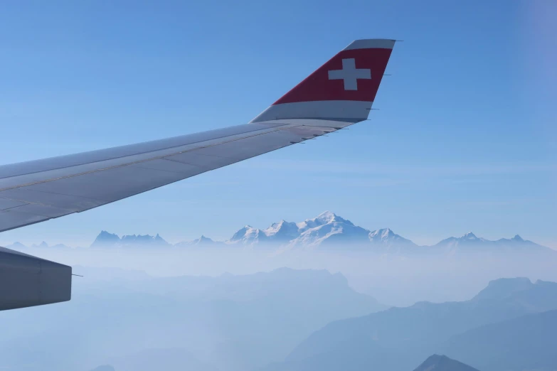 a view from the top of an airplane wing over mountains