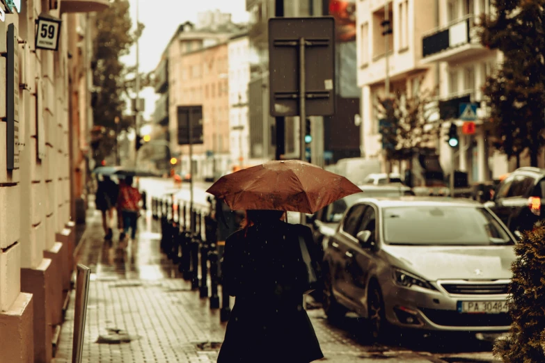 a woman is holding an umbrella on the street