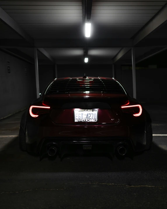 the rear end of a sports car in a dark parking lot