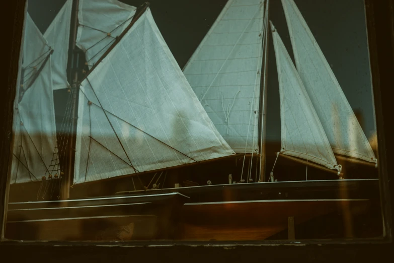 sail boats behind glass in a building