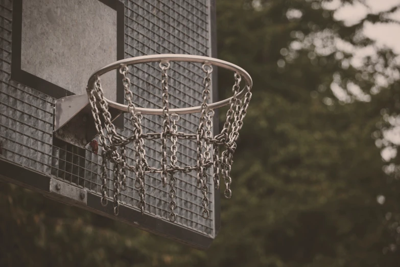 the backboard of an outside basketball hoop with chains hanging down