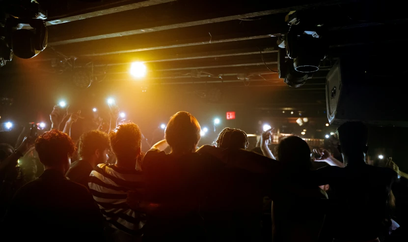 a crowd of people standing in front of a stage
