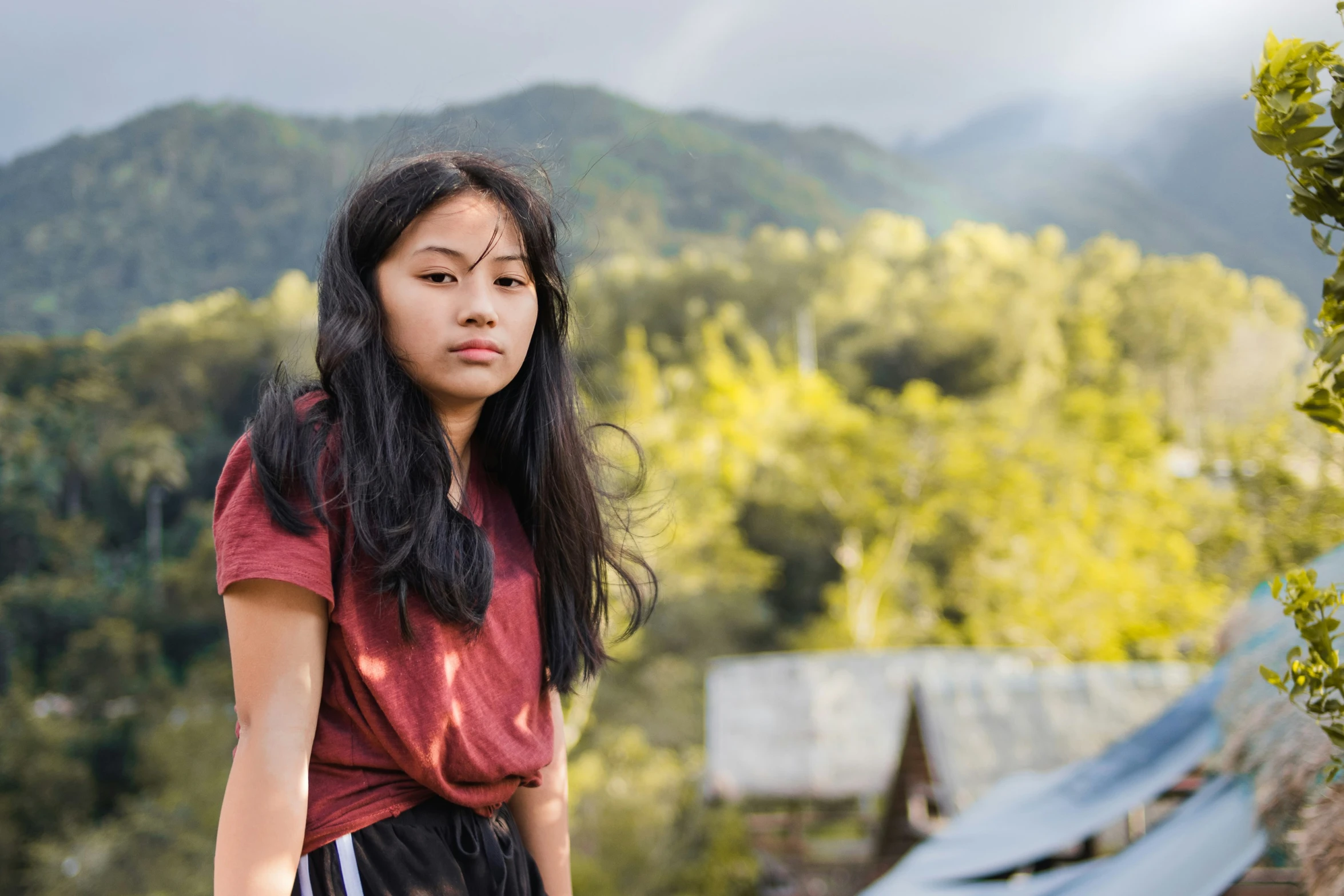 a  with long hair is standing in the outdoors