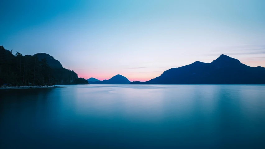 an ocean that is full of mountains and blue sky