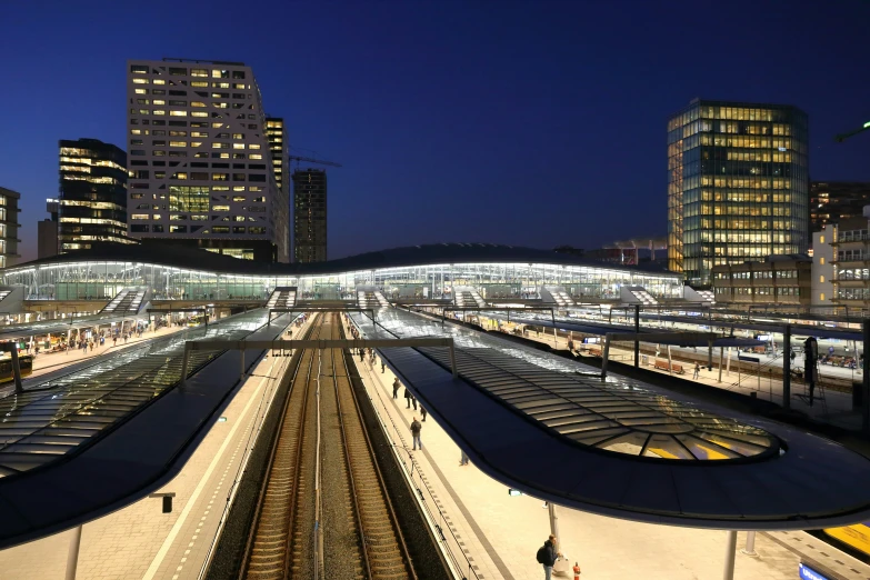 a night time picture of a train station and buildings