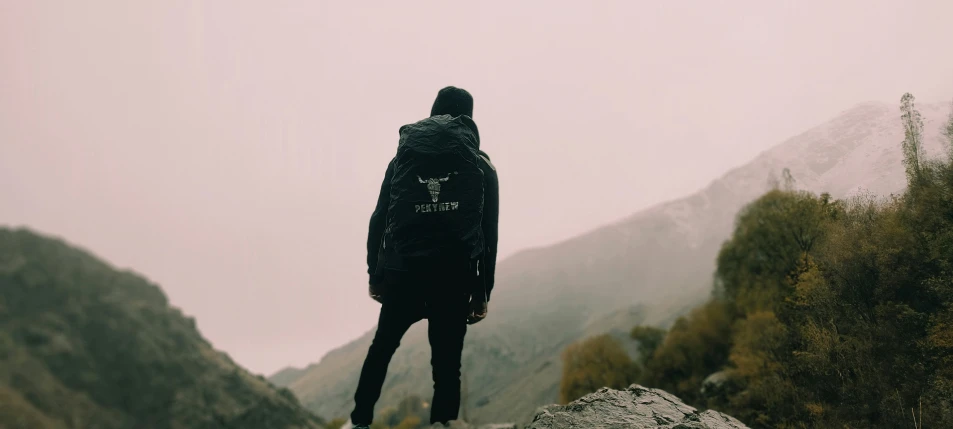 a man in the mountains looking up at mountains