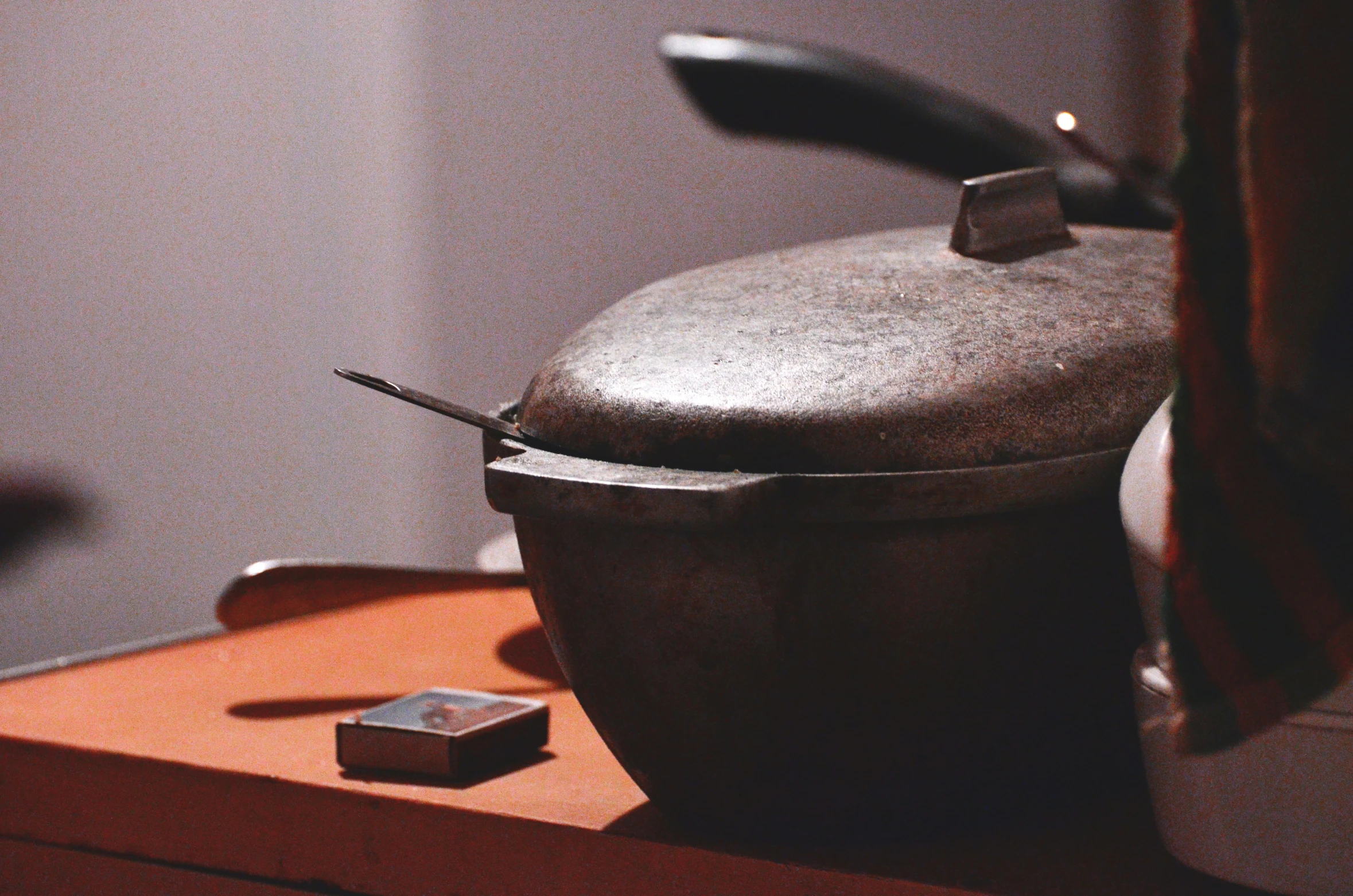 there is an old kettle and a piece of metal on the table