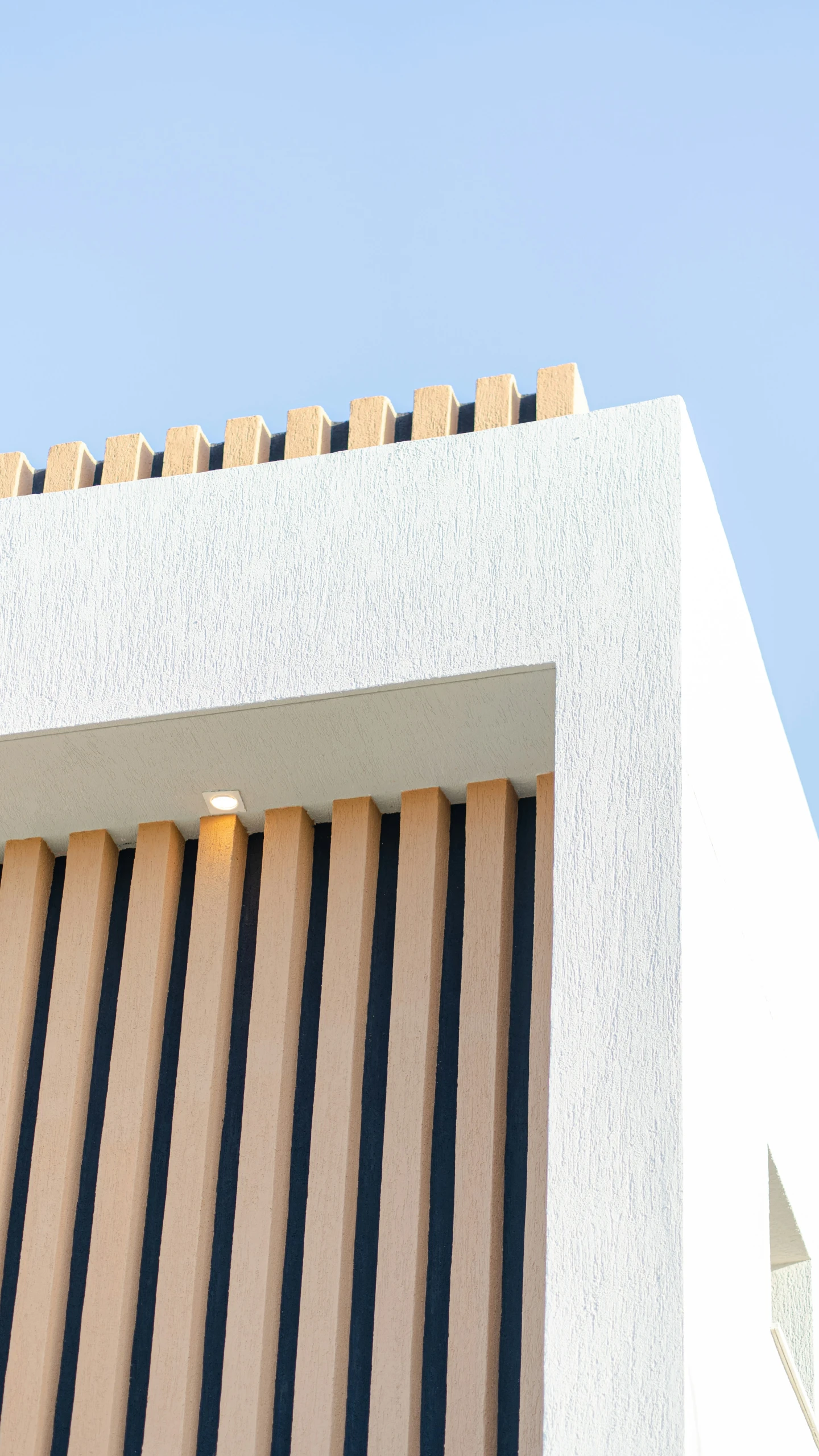 a tan, vertical striped building with a large clock on the outside of it