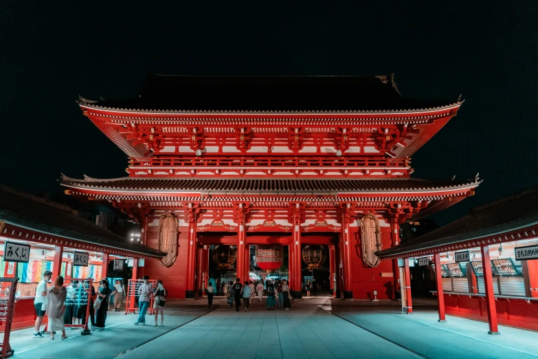 many people are standing outside of a red building