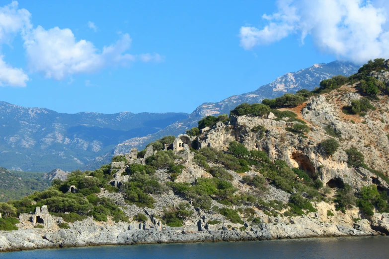 a blue mountain is shown with trees and a body of water