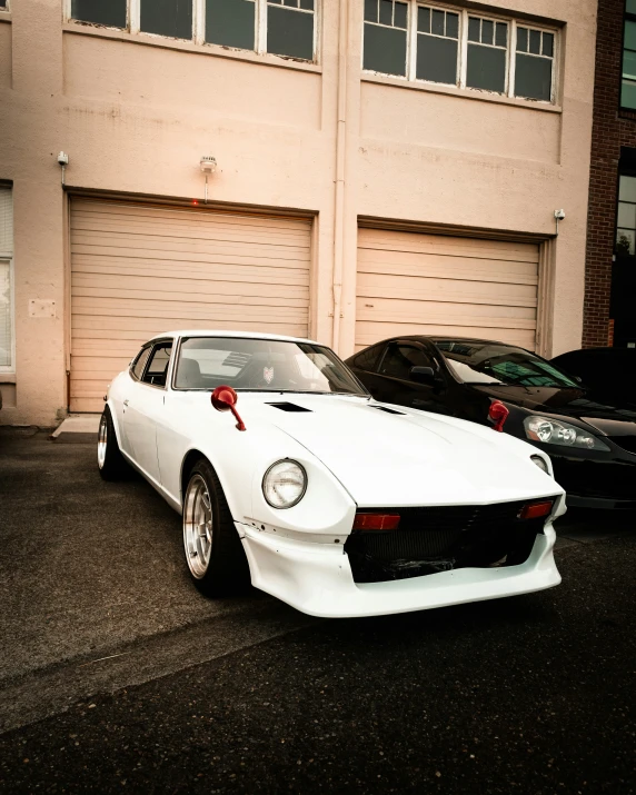 a white car in a parking lot next to a garage