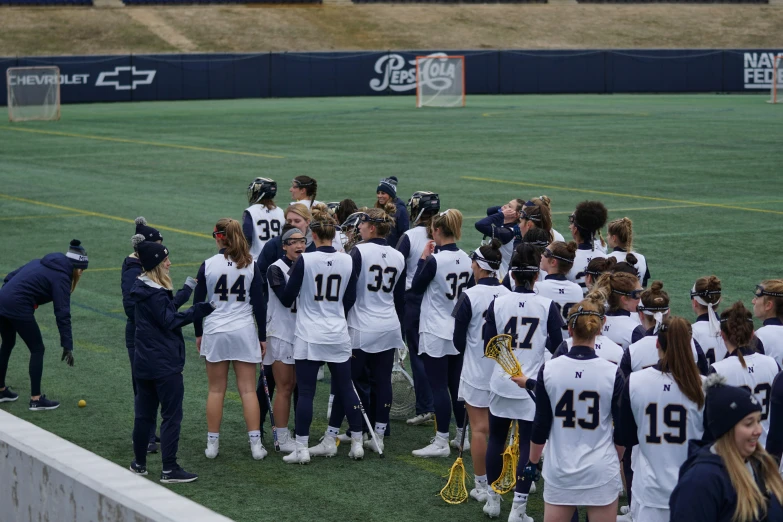 a large team of women's soccer players in uniforms are standing on the field