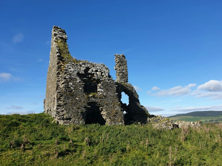 there is an old abandoned building on the side of the hill