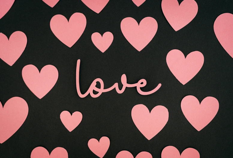 a black background has hearts written in pink on it