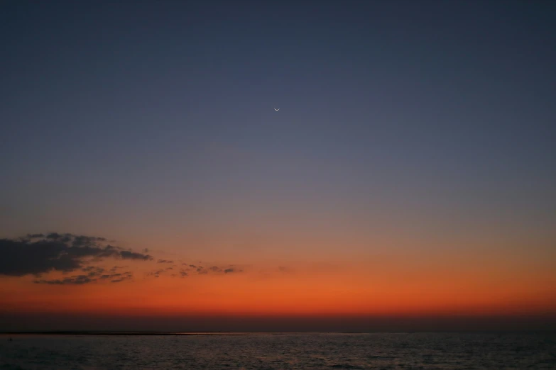 an orange and blue sunset is over the ocean