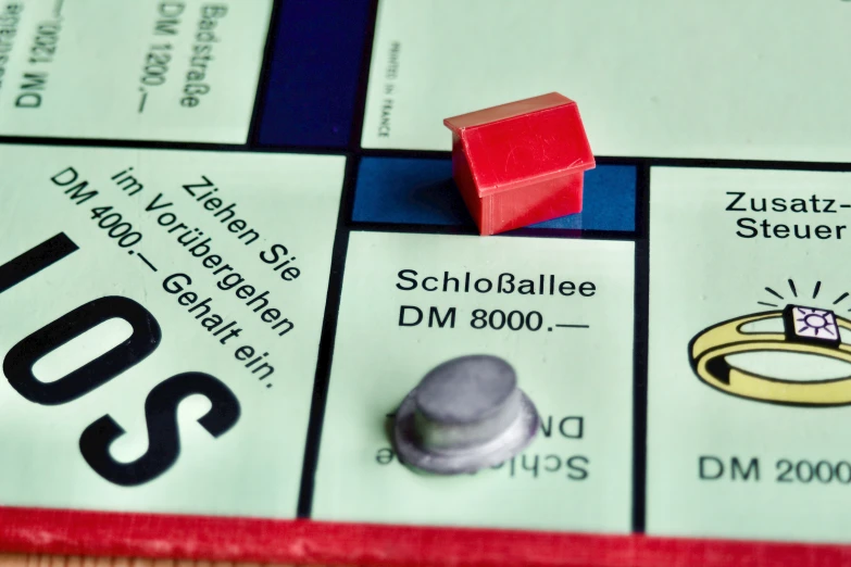 a monopoly board with a red object placed on top of it