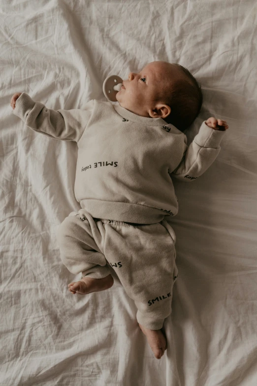 baby lays on its back and plays with the string