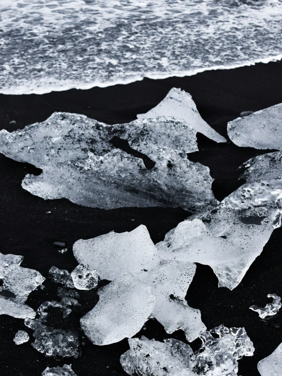 ice on the black sand beach next to the ocean