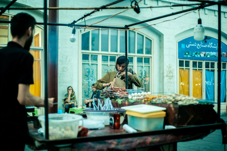 people stand at tables and look in the window