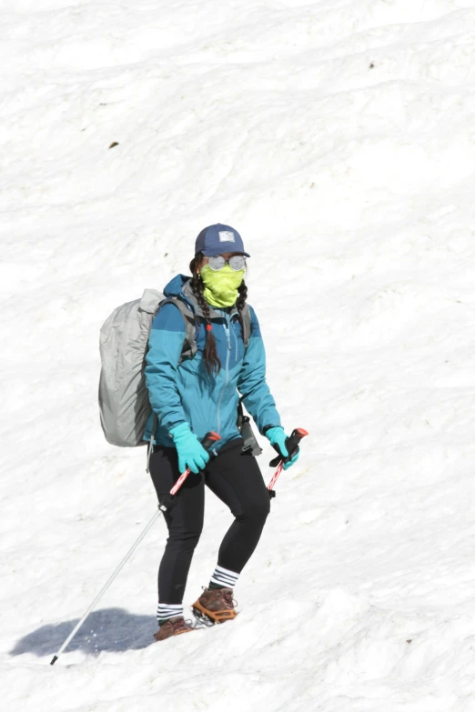 a person skiing in the snow wearing a blue jacket