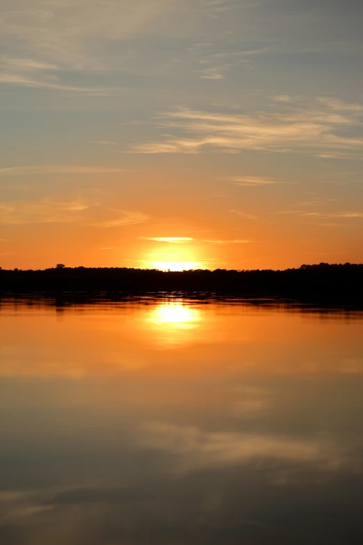 a beautiful sunset over a lake with clouds