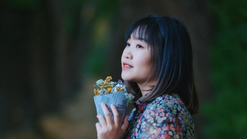 an asian woman is eating and talking on a cell phone