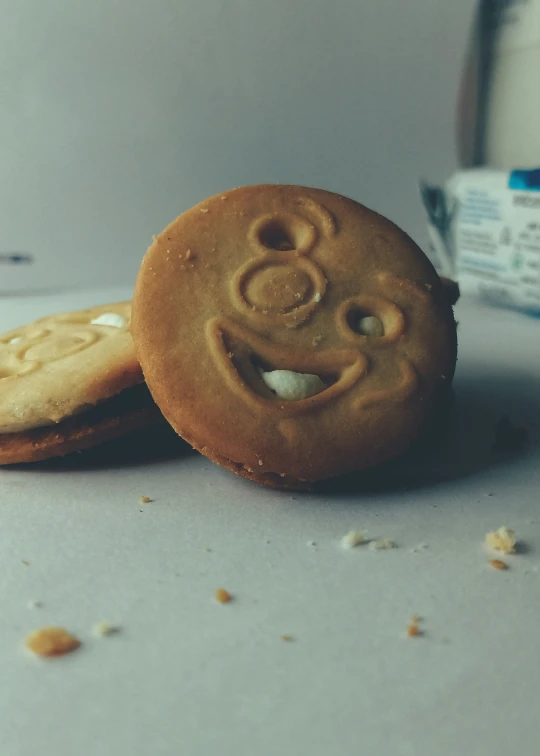 the two cookies are decorated like smiley faces