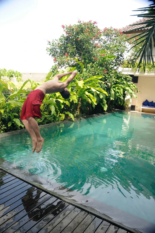 man diving into the pool from the patio