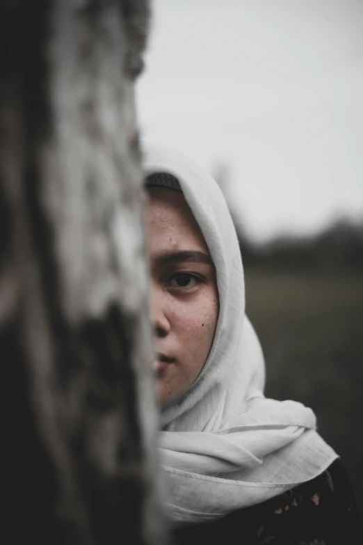 a woman looking back with a white headscarf