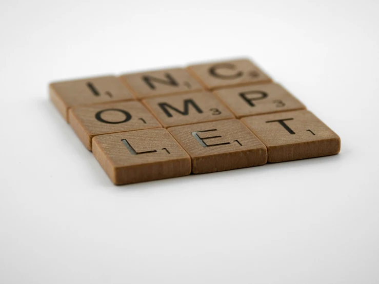 the words lincompple lie on wooden tiles