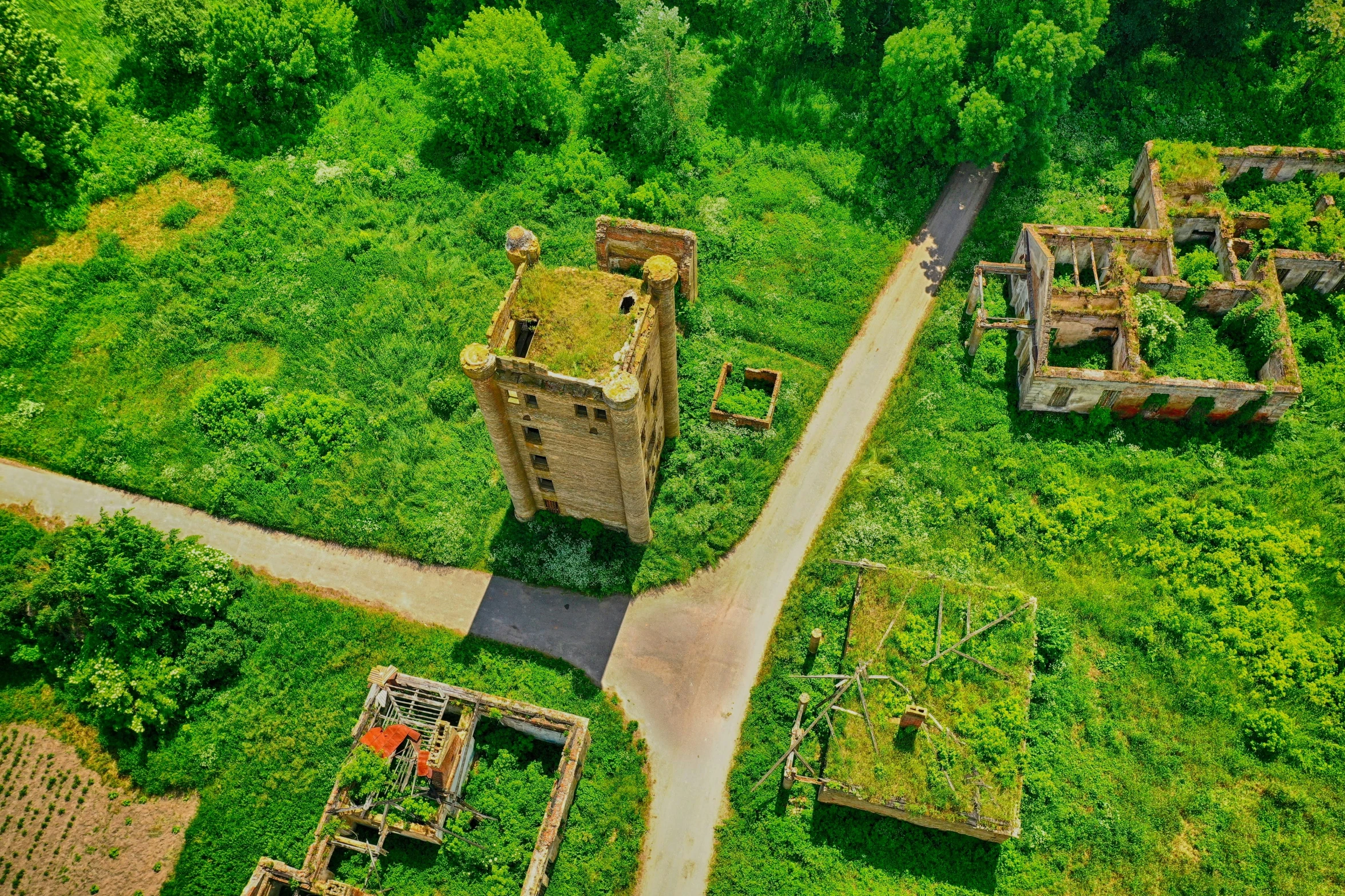 an old abandoned building in a lush green field