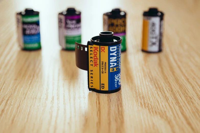 several batteries and a can sit on a wooden table