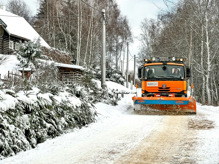 a large tractor moving through the snow covered land