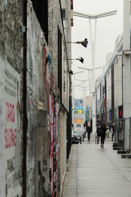 people walking down a street past tall buildings