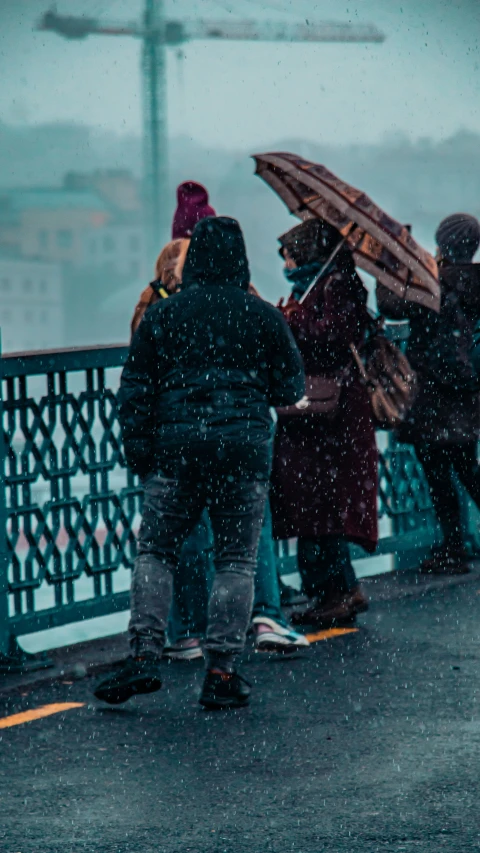 several people standing under an umbrella in the rain